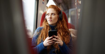 Young woman listening to an advert while on the train
