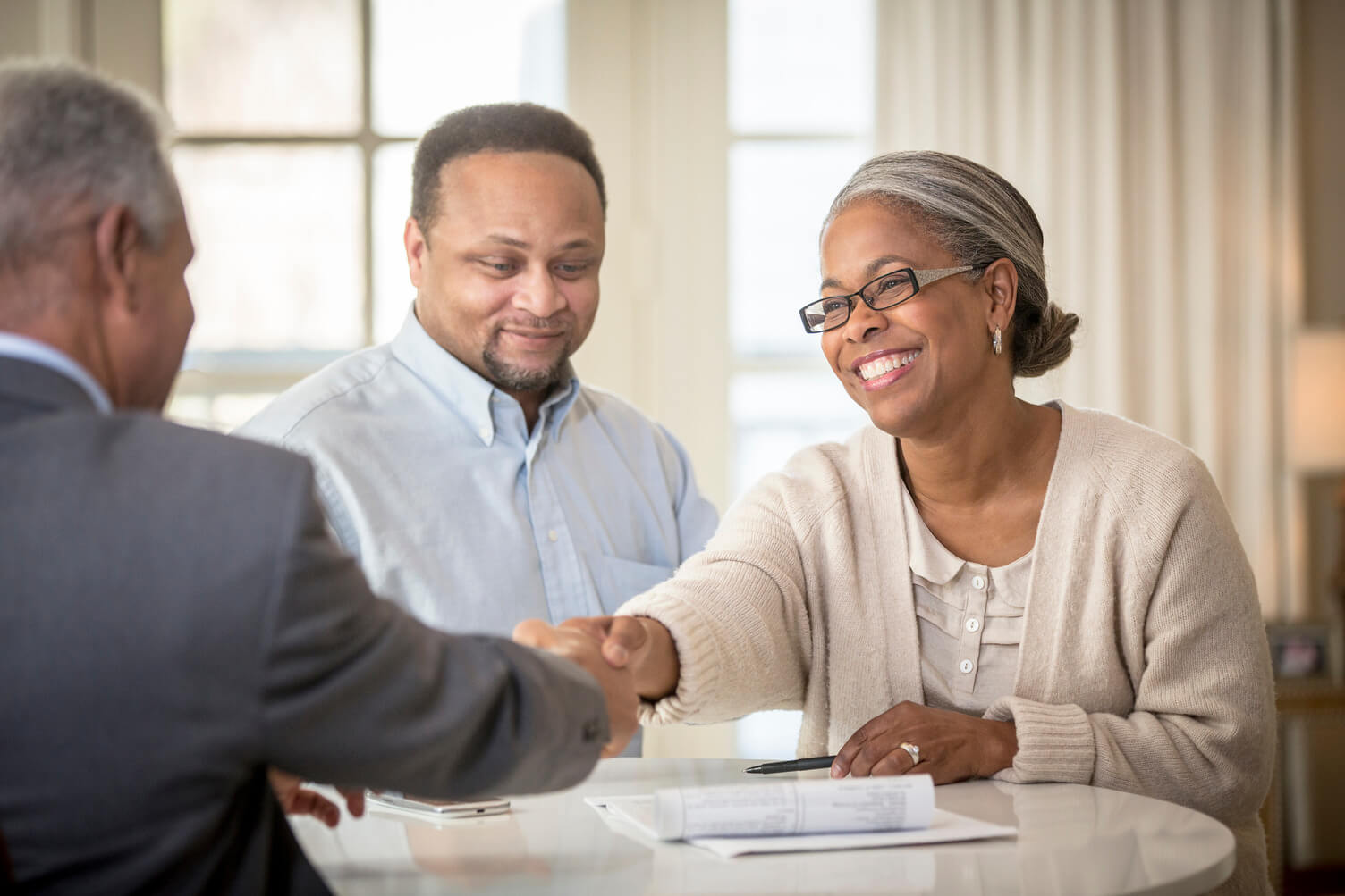 Couple shaking hands with a bank manager