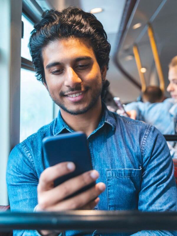 Man on a bus applying for credit on his mobile phone